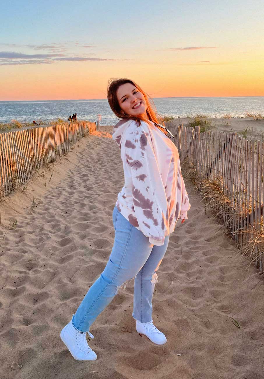 Coach standing smiling by the beach